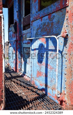 old abandoned rusty metal painted railroad train caboose Royalty-Free Stock Photo #2452324389