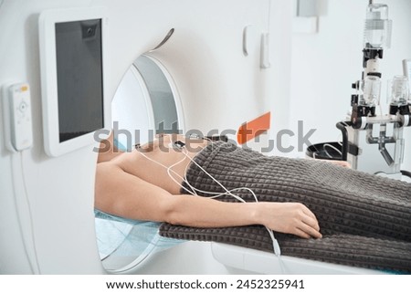 Man undergoing contrast-enhanced ECG-gated coronary CT angiography procedure