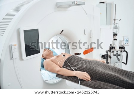 Man undergoing contrast-enhanced ECG-gated coronary CT angiography procedure