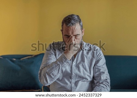 Bearded Businessman Feeling Tired Exhausted, Chronic Work Stress. Man Suffering From Headache After Hard Working Day, Sitting On Couch At Home Royalty-Free Stock Photo #2452337329