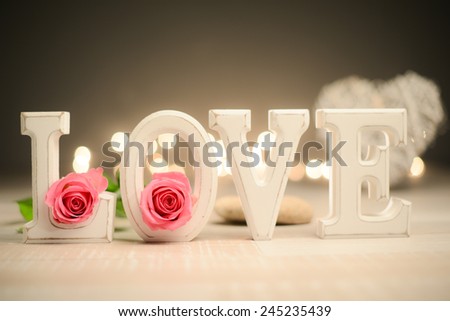 love symbol still life with letters, heart shape flowers and lights