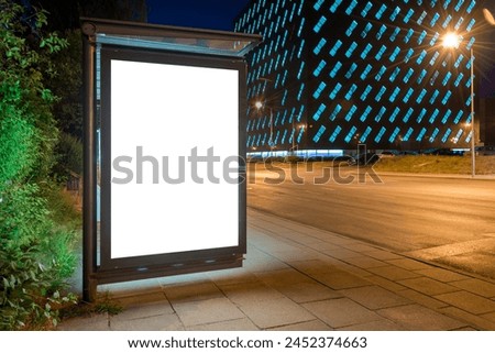 Blank White Mockup Of Bus Stop Vertical Billboard In Front Of Modern Building. Outdoor Advertising Lightbox On A City Street