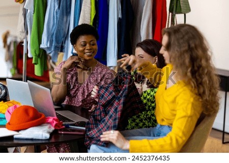 Group of young women creating small modern business start up, project for fashion design, clothes creation. Concept of people at work, purchasing and online shopping. Friends learning, college life
