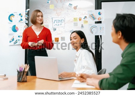 Professional attractive female leader presents creative marketing plan by using brainstorming mind mapping statistic graph and colorful sticky note at modern business meeting room. Immaculate. Royalty-Free Stock Photo #2452385527