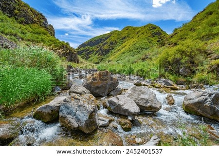 Experience the serene flow of the river through the majestic mountains. Feel connected to the beauty of nature as you explore the rocky canyon. Immerse yourself in a peaceful and tranquil environment