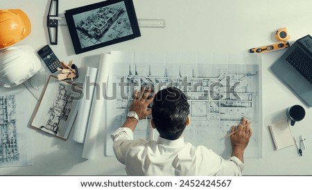 Top view of skilled civil engineer sitting and writing idea while looking at house model. Aerial view of architect or designer planning and thinking about creative building construction. Alimentation. Royalty-Free Stock Photo #2452424567