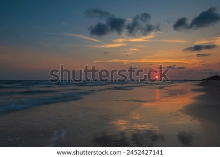 Beautiful  seascape  with  dramatc  golden  sky  over  the sea  and  reflection  at  sunset  time  in  the  summer,long  time  exposure.