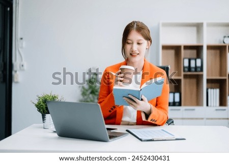 Asian businesswoman working in the office with working notepad, tablet and laptop documents 

