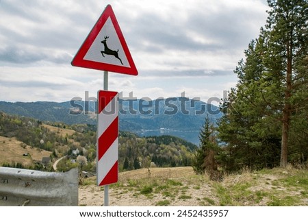 Traffic sign warns about wild animals crossing the road,road warning signs Royalty-Free Stock Photo #2452435957