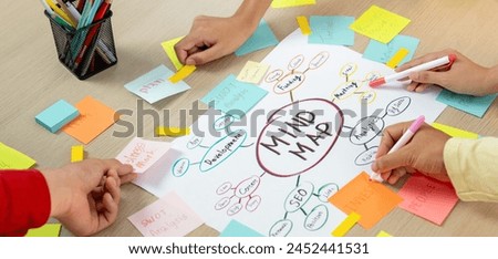 Creative business team brainstorming about marketing strategy and business plan by using mind mapping. Startup team work together to write down on paper. Focus on hand. Closeup. Variegated. Royalty-Free Stock Photo #2452441531
