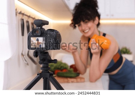 Food blogger explaining something while recording video in kitchen, focus on camera Royalty-Free Stock Photo #2452444831