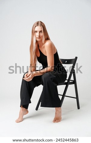 Young Woman Sitting on Chair Posing for Picture