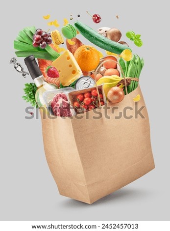 Food or groceries flying out from paper shopping bag on white background. File contains clipping paths. Royalty-Free Stock Photo #2452457013