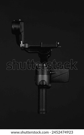 Black gimbal photography captures the art of smooth and stable shots using a sleek black gimbal device. Royalty-Free Stock Photo #2452474923