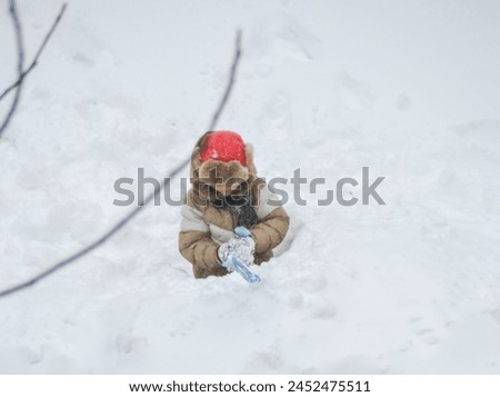 Boy little child have fun playing in a snow fort on a sunny winter day. Winter retro clothes for cold weather. High quality photo