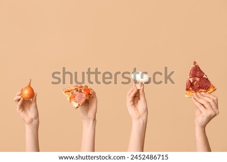 Many hands holding pizza slices, onion and mushroom on beige background