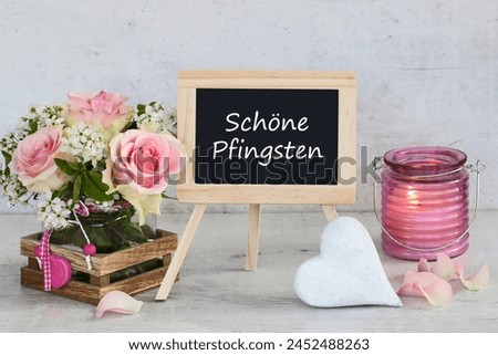 .Bouquet of roses with a heart and the text beautiful Pentecost on a chalkboard. German inscription translates as beautiful Pentecost. Royalty-Free Stock Photo #2452488263
