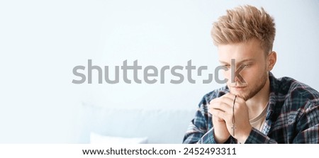 Religious young man praying at home. Banner for design