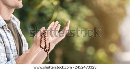 Religious young man praying outdoors, closeup. Banner for design
