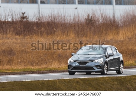 Compact european car on the suburban rural highway.