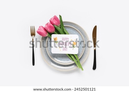 Table setting with greeting card for Mother's day and tulips isolated on white background Royalty-Free Stock Photo #2452501121