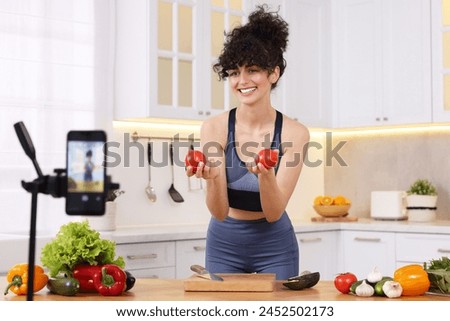Smiling food blogger explaining something while recording video in kitchen Royalty-Free Stock Photo #2452502173