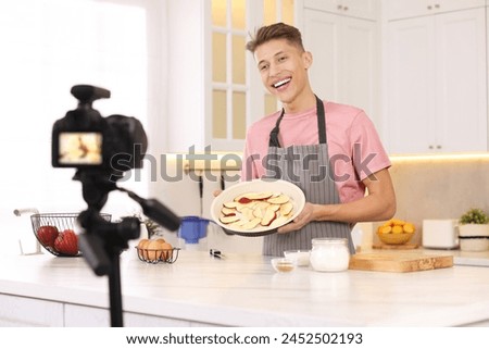 Smiling food blogger explaining something while recording video in kitchen Royalty-Free Stock Photo #2452502193