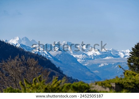 Scenic rural landscape with snow covered mountains with Eiger, Monk and Virgin peaks seen from Swiss Bürgenstock mountain on a sunny spring day. Photo taken April 11th, 2024, Bürgenstock, Switzerland.