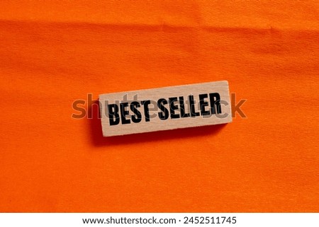 Best seller words written on wooden block with orange background. Conceptual best seller symbol. Copy space.