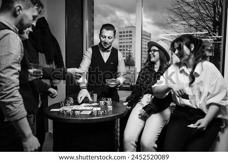 Ivano-Frankivsk, Ukraine February 23, 2024: five young people playing poker and drinking jack daniels whiskey, team in barbershop.
