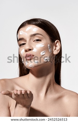 A beautiful young woman wearing a white cream on her face, adding an element of mystique and elegance to her appearance.
