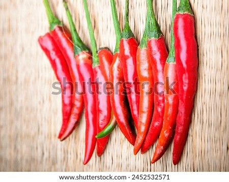 a photography of a group of red hot peppers on a wooden surface.