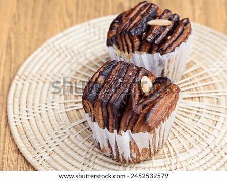 a photography of two cupcakes on a plate on a table.