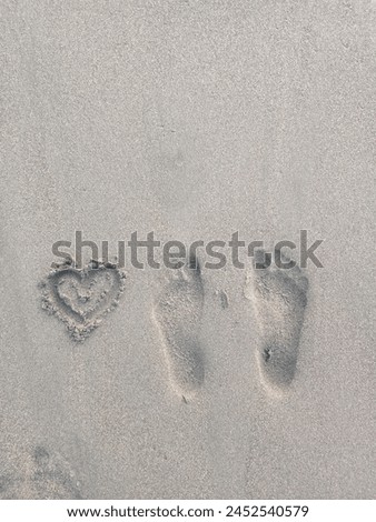 Footprint in the beach sand with a picture of love