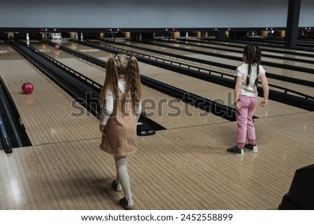 Kids, little girls playing bowling. 