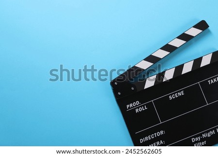 Clapperboard on light blue background, top view. Space for text