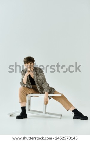 A middle-aged woman sitting gracefully atop a white chair in a stylish setting, exuding elegance and poise. Royalty-Free Stock Photo #2452570145