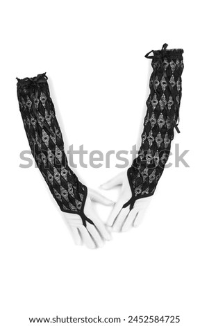 Close-up shot of a black long fingerless gloves with pattern. The pair of black openwork mittens is isolated on a white background. Front view. Royalty-Free Stock Photo #2452584725