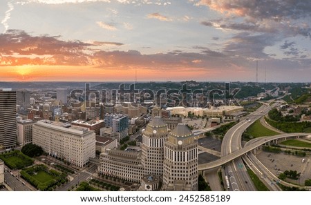 Aerial view of downtown district of Cincinnati city in Ohio, USA at sunset. Brightly illuminated high skyscraper buildings in modern American midtown.