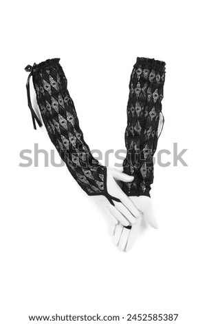 Close-up shot of a black long fingerless gloves with pattern. The pair of black openwork mittens is isolated on a white background. Front view. Royalty-Free Stock Photo #2452585387
