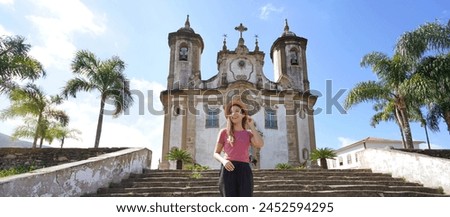 Panoramic banner view of beautiful tourist woman visiting the baroque colonial city of Ouro Preto, old capital of the state of Minas Gerais, Brazil, UNESCO world heritage site