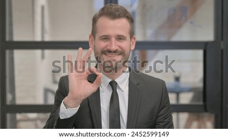 Portrait of Middle Aged Businessman with Okay Sign