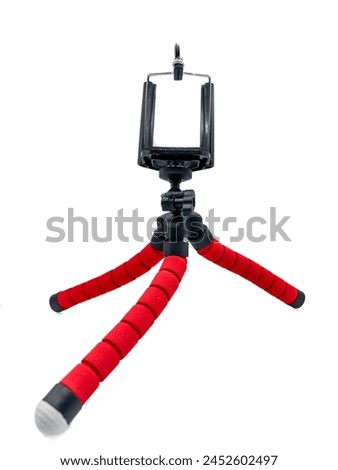 A red and black tripod with a camera attached to it. The tripod is designed to be used for taking pictures and videos