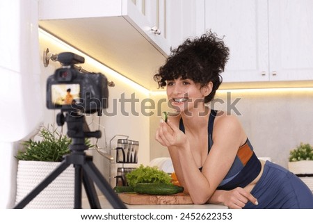 Smiling food blogger explaining something while recording video in kitchen Royalty-Free Stock Photo #2452622353
