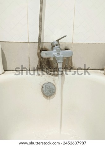 A picture capturing a bathtub being filled by a faucet, with flowing water creating mesmerizing ripples on the surface, evoking a sense of relaxation and tranquility