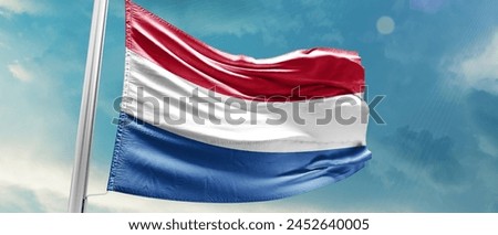 Netherlands national flag waving in beautiful sky.