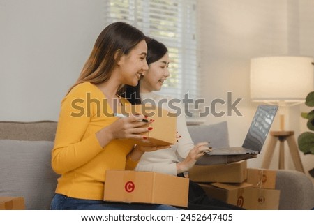 Two business owners are checking customer information on a package before it is delivered to the buyer, Two co-workers are checking that order data matches sales figures. Royalty-Free Stock Photo #2452647405