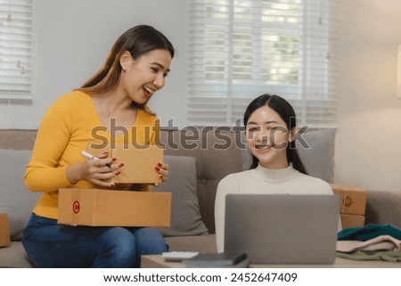 Two business owners are checking customer information on a package before it is delivered to the buyer, Two co-workers are checking that order data matches sales figures. Royalty-Free Stock Photo #2452647409
