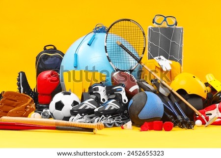 Many different sports equipment on yellow background