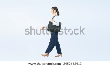 Full body photo of a Caucasian female business person walking 